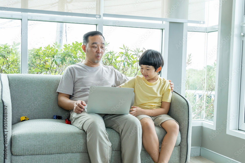 Happy Asian family male and female parents Teaching or helping with their children's homework. On holiday. Staying at home happily. Happy Asian family male and female parents Teaching or helping with their children's homework. On holiday. Staying at home happily.
