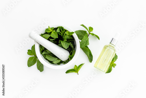 Peppermint essential oil - source of menthol. Mint leaves with bottle of oil