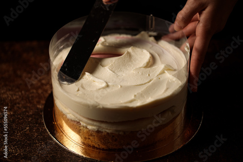 Tableau sur toile assembling the cake in an acetate film in a dark background cream distribution