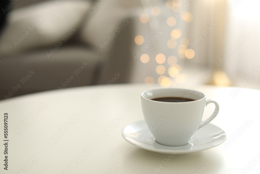 Cup of coffee on table indoors, space for text. Bokeh effect Cup of coffee on table indoors, space for text. Bokeh effect