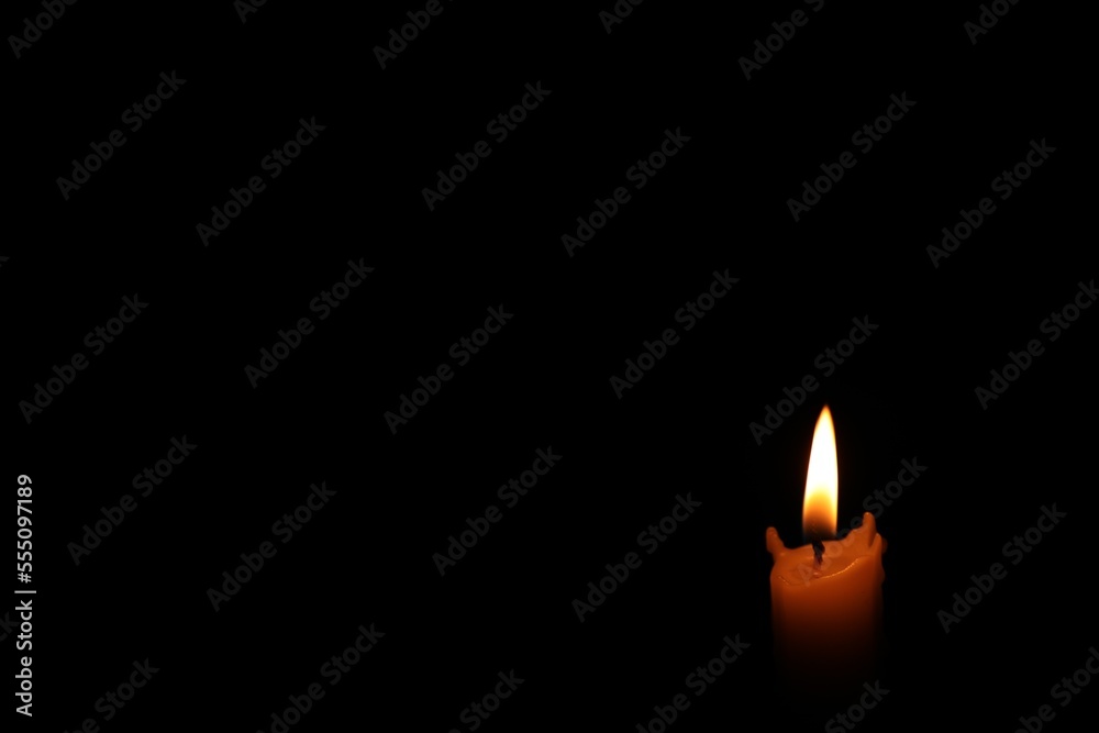 Burning wax candle in darkness. Space for text Burning wax candle in darkness. Space for text