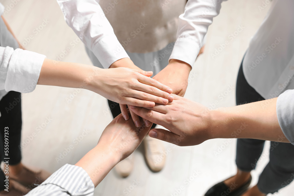 © New Africa - Group of people holding hands together indoors, above view. Unity concept