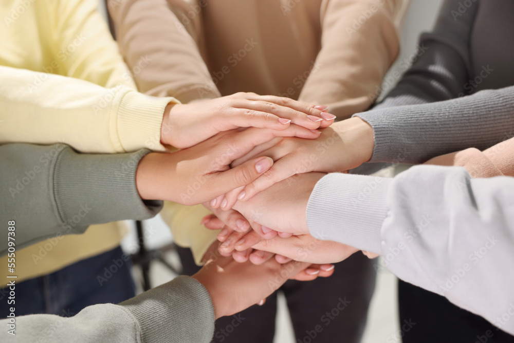 Group of people holding hands together indoors, closeup. Unity concept