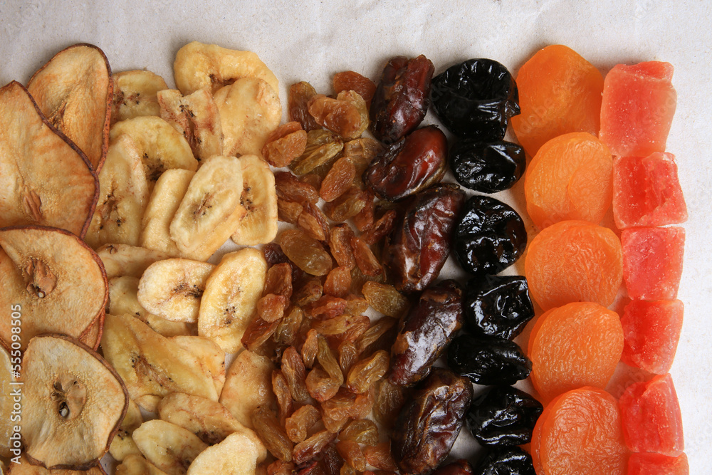Different tasty dried fruits on paper, flat lay Different tasty dried fruits on paper, flat lay