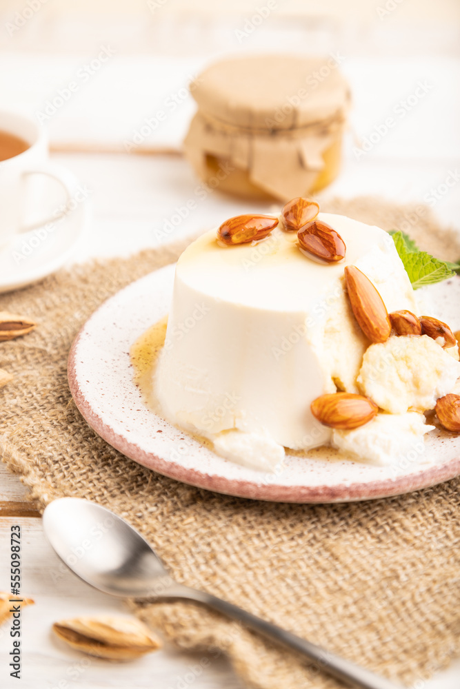 Ricotta cheese with honey and almonds on white wooden. side view, selective focus. Ricotta cheese with honey and almonds on white wooden. side view, selective focus.