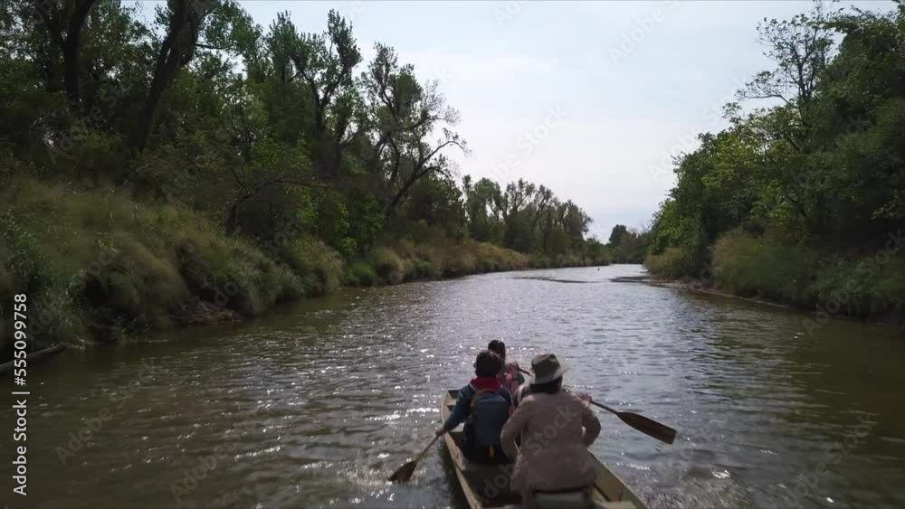Slow overhead flyover of a family padding up a small river in the Georgian countryside Slow overhead flyover of a family padding up a small river in the Georgian countryside