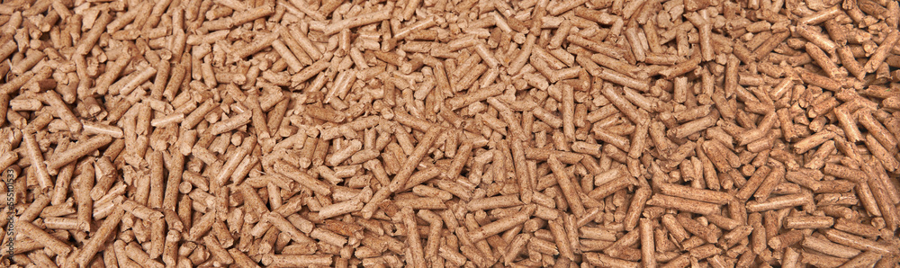 Wooden pellet top view. Long banner image copy space. Close-up of ecological and sustainable fuel. Renewable house heating material. Woodpellet macro. Wooden pellet top view. Long banner image copy space. Close-up of ecological and sustainable fuel. Renewable house heating material. Woodpellet macro.