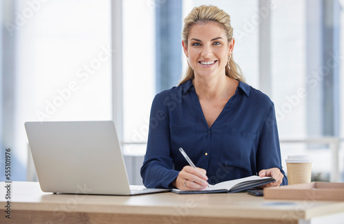 Portrait, business woman and writing in book in office with laptop on desk. Face, notes and happy female manager from Canada with notebook, diary or journal for schedule, marketing ideas or planning.