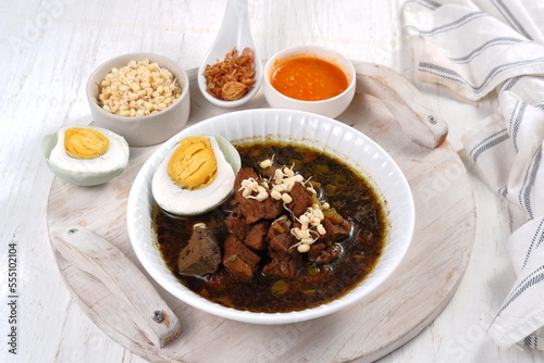 Rawon is Beef Black Soup Originally from East Java, Indonesia.served with salted egg,bean sprouts,and chilli sauce 