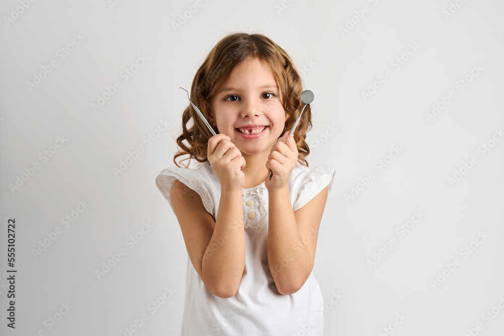 Dentist girl holding dental tools on white background Dentist girl holding dental tools on white background