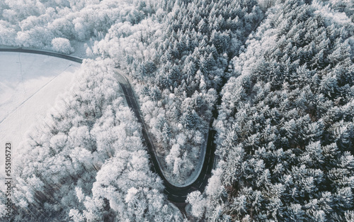 high angle view of winding road going up the mountain in beautiful winter forest © Anselm