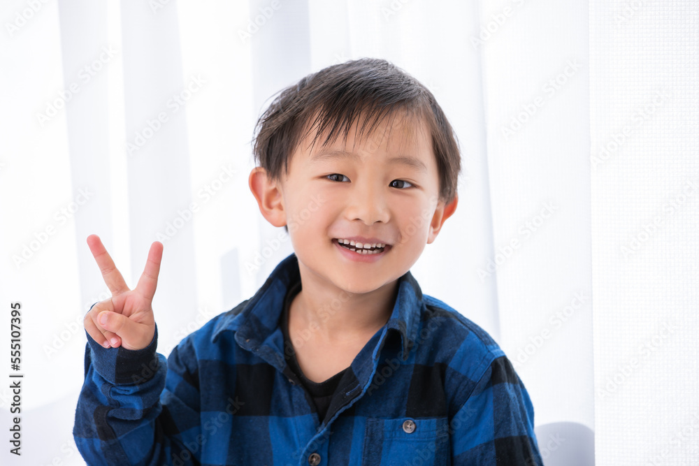 ピースサインをする笑顔の男の子 5歳 ピースサインをする笑顔の男の子 5歳