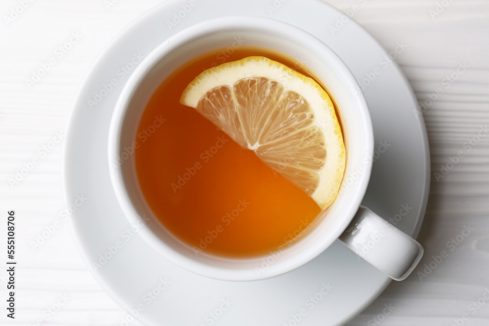 Cup with delicious immunity boosting tea and lemon on white wooden table, top view Cup with delicious immunity boosting tea and lemon on white wooden table, top view