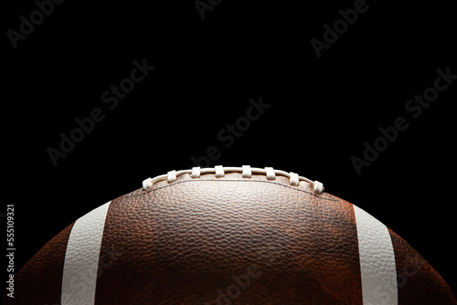 American football ball on dark background with space for text.