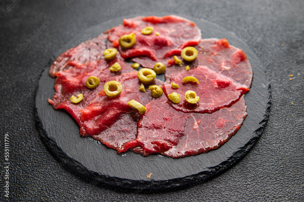 carpaccio raw meat spice appetizer olives, beef thin slices fresh healthy meal food snack on the table copy space food background rustic top view carpaccio raw meat spice appetizer olives, beef thin slices fresh healthy meal food snack on the table copy space food background rustic top view