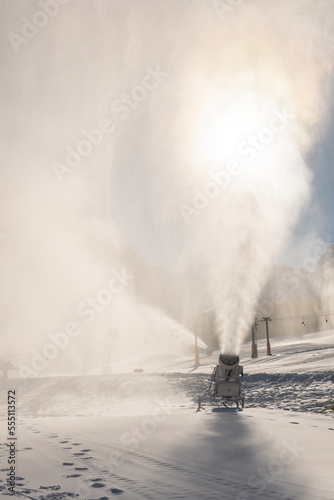 Snowmaking machine snow cannon or gun in action on a cold sunny winter day in ski resort Kranjska Gora, Slovenia