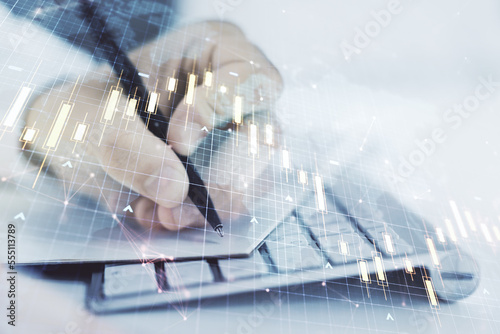 Double exposure of abstract creative financial diagram with world map and with hand writing in notepad on background with laptop  banking and accounting concept