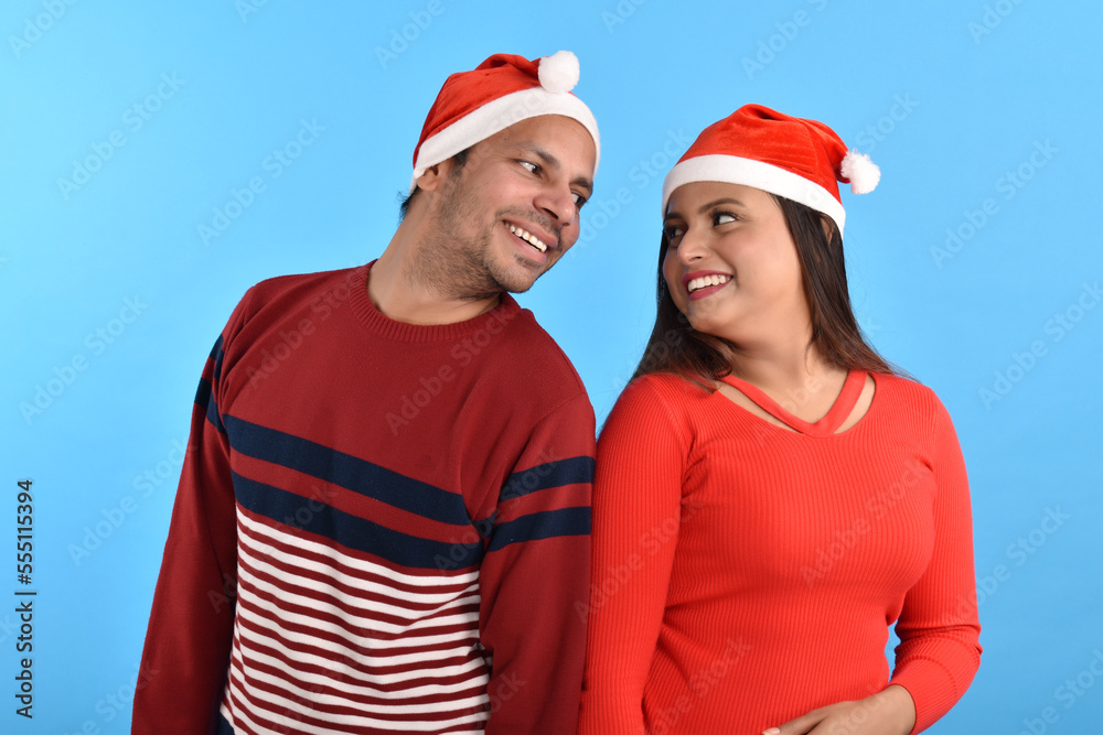 Happy Young couple wearing santa hats Happy Young couple wearing santa hats