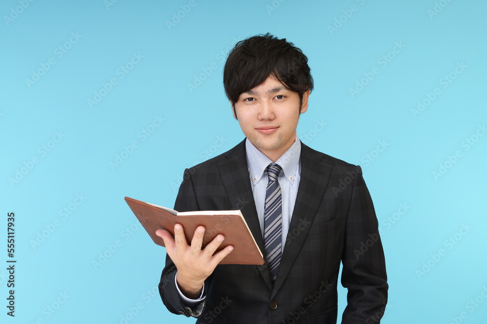 ノートを持つ男性