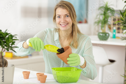 beautiful woman planting a potted plant at her home