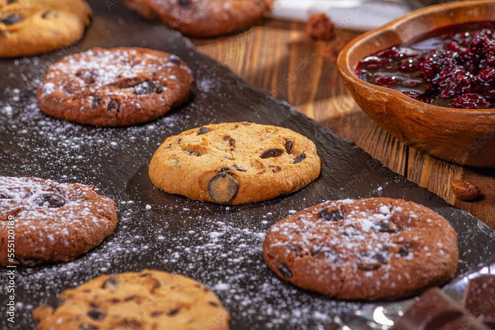 Cookies with chocolate and coffee on a wooden table, selective focus, close up