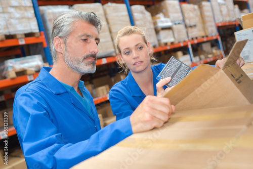 Foto Male and female warehouse workers looking in box