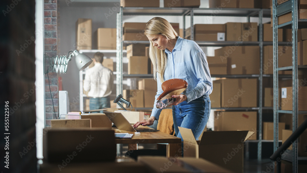 Inventory Manager Packaging a Stylish Bicycle Seat Sold to a Client Online. Preparing a Small Cardboard Parcel for Postage. Blond Female Small Business Owner Working in Warehouse. Inventory Manager Packaging a Stylish Bicycle Seat Sold to a Client Online. Preparing a Small Cardboard Parcel for Postage. Blond Female Small Business Owner Working in Warehouse.