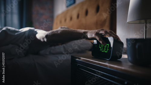 Man Wakes Up and Turns off Alarm Clock. Early Rising Productive Man Ready Start a Day full of New Adventures. Bedside Nightstand Focus on the Clock Showing Four O'Clock. Bedroom Apartment