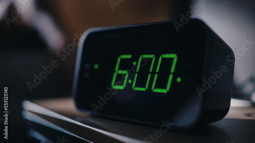 Person Wakes Up and Turns off Alarm Clock. Early Rising Productive Person Ready Start a Day with New Adventures. Close-up Focus on the Clock Showing Six A.M. Bedside Nightstand bedroom Apartment