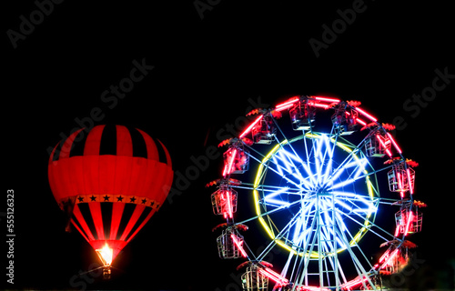 hot air balloon glow at night and ferris wheel