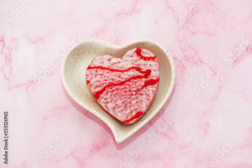 Sweet white glazed cookies in the shape of a heart with a red pattern