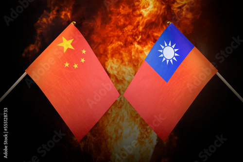 Flags of china and taiwan against background of a fiery explosion. The concept of enmity and war between countries. Tense political relations.
