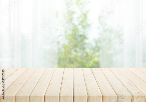 Selective focus.Empty of wood table top on blur of curtain with window and green from garden background.