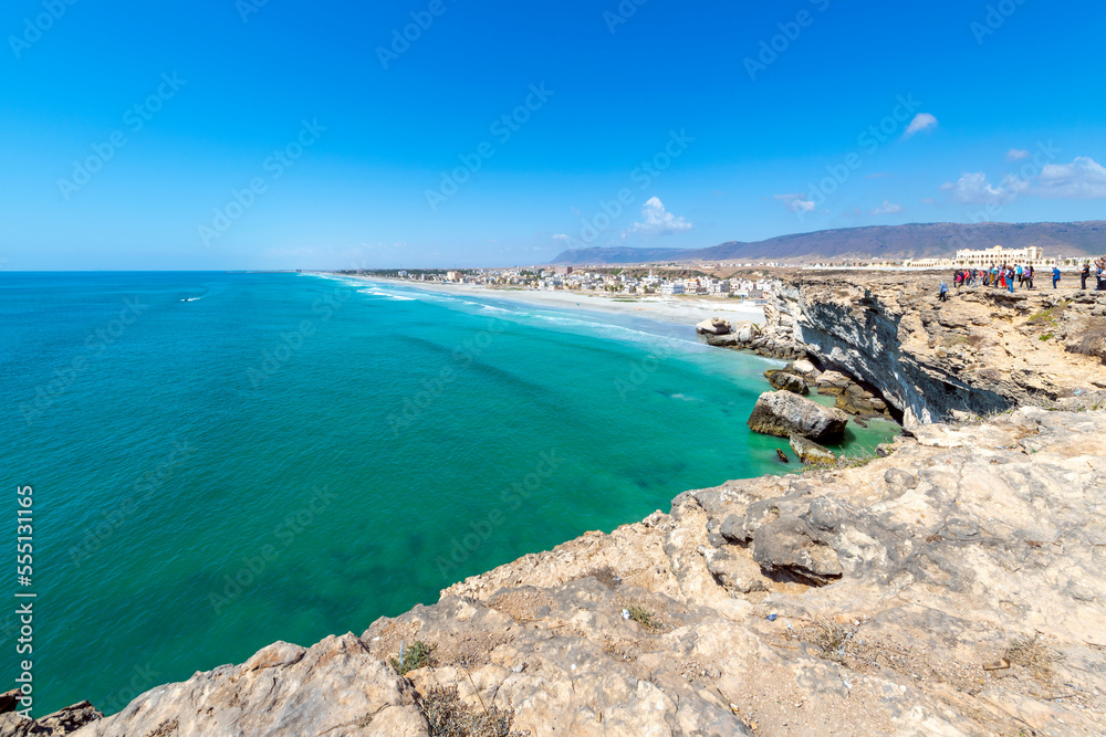 The village of Taqah and it's white sandy Taqah Beach seen from the cliffs rising above the Arabian Sea near Salalah, Oman.