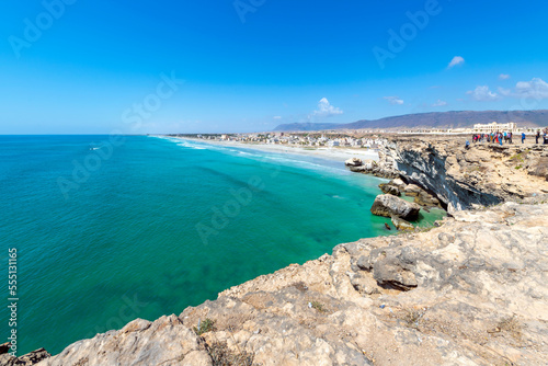 The village of Taqah and it's white sandy Taqah Beach seen from the cliffs rising above the Arabian Sea near Salalah, Oman.
