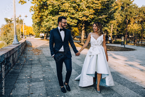 bride and groom walking in the park