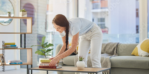Картината върху платно Woman, cleaning and house with books in lounge, table and organize for housekeeping, tidy and order
