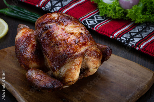 Rotisserie Chicken or grilled served in wooden board isolated on table top view of arabic food photo