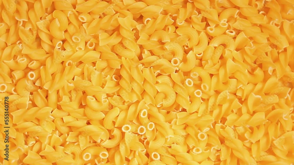 Uncooked Fusilli and Chifferi Rigati Pasta - Top View. Fat and Unhealthy Food. Classic Dry Macaroni, Slowly Rotating Background. Raw Different Macaroni Pasta Texture - Rotate Left Uncooked Fusilli and Chifferi Rigati Pasta - Top View. Fat and Unhealthy Food. Classic Dry Macaroni, Slowly Rotating Background. Raw Different Macaroni Pasta Texture - Rotate Left