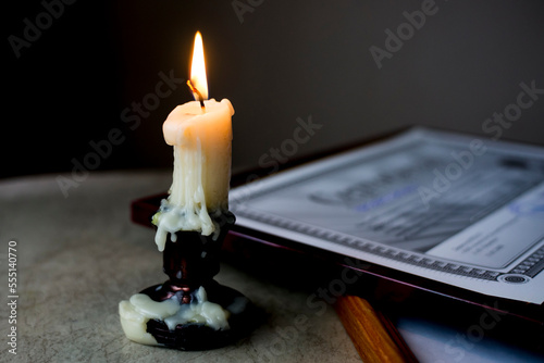 A burning candle on the table in front of the frame. Soft focus