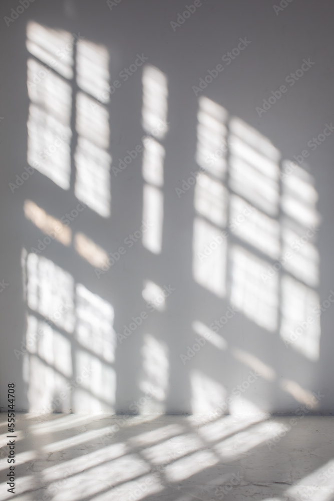 Fragment of room with empty white wall where sunlight shining through a window - concept of sunbeams to overlay a photo
