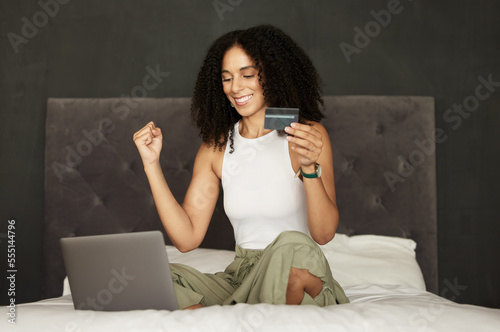 Black woman, credit card and laptop on bed for ecommerce, celebration and discount on internet. Woman, online shopping and e commerce in bedroom with happiness, cybersecurity and sale at web store