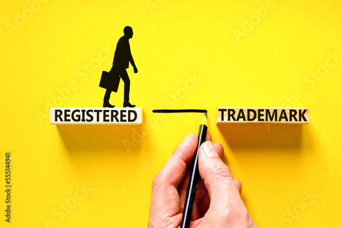Registered trademark symbol. Concept word Registered trademark on wooden blocks. Beautiful yellow table yellow background. Businessman hand. Business and registered trademark concept. Copy space. photo