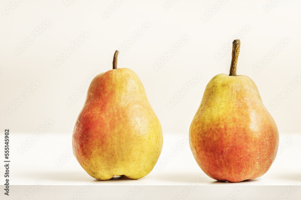 Two delicious ripe pears on a white surface Two delicious ripe pears on a white surface
