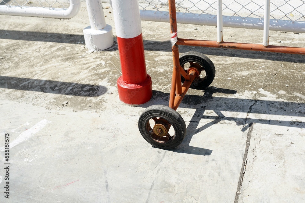  A barrier to caution on area of a pump control of the gas station.