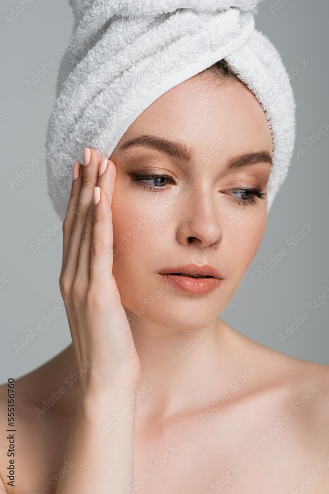 portrait of young woman with towel on head looking away isolated on grey portrait of young woman with towel on head looking away isolated on grey