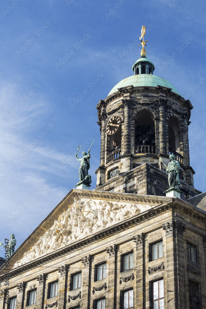 Close-up of decorative building facade with round clock tower and statues on top; Amsterdam, Netherlands Close-up of decorative building facade with round clock tower and statues on top; Amsterdam, Netherlands