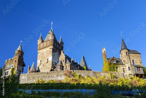Looking up to old medieval stone castle with blue sky; Cochem, Germany photo