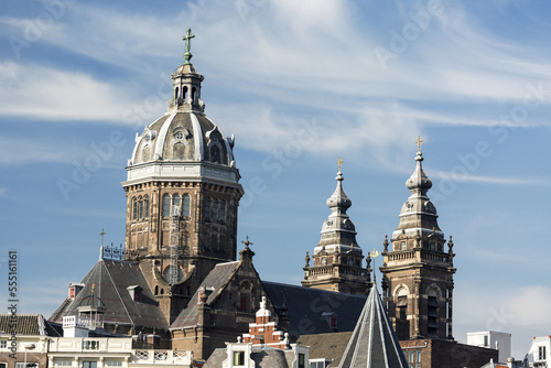 Large domed tower of Basilica of Saint Nicholas with two additional towers blue sky and clouds; Amsterdam, Netherlands photo