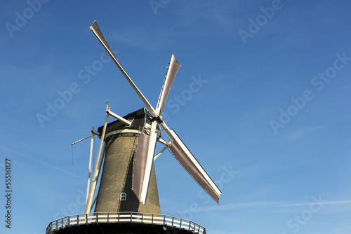 Looking up at old wooden windmill with blue sky; Leiden, Netherlands photo